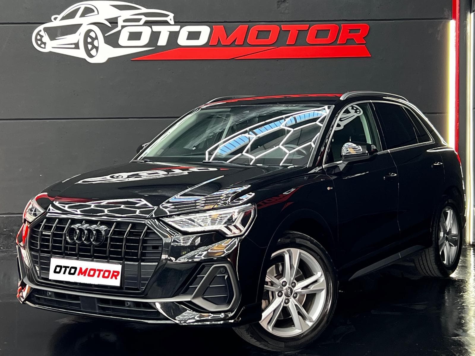 Audi Q3 S line negro, vista frontal en showroom OtoMotor