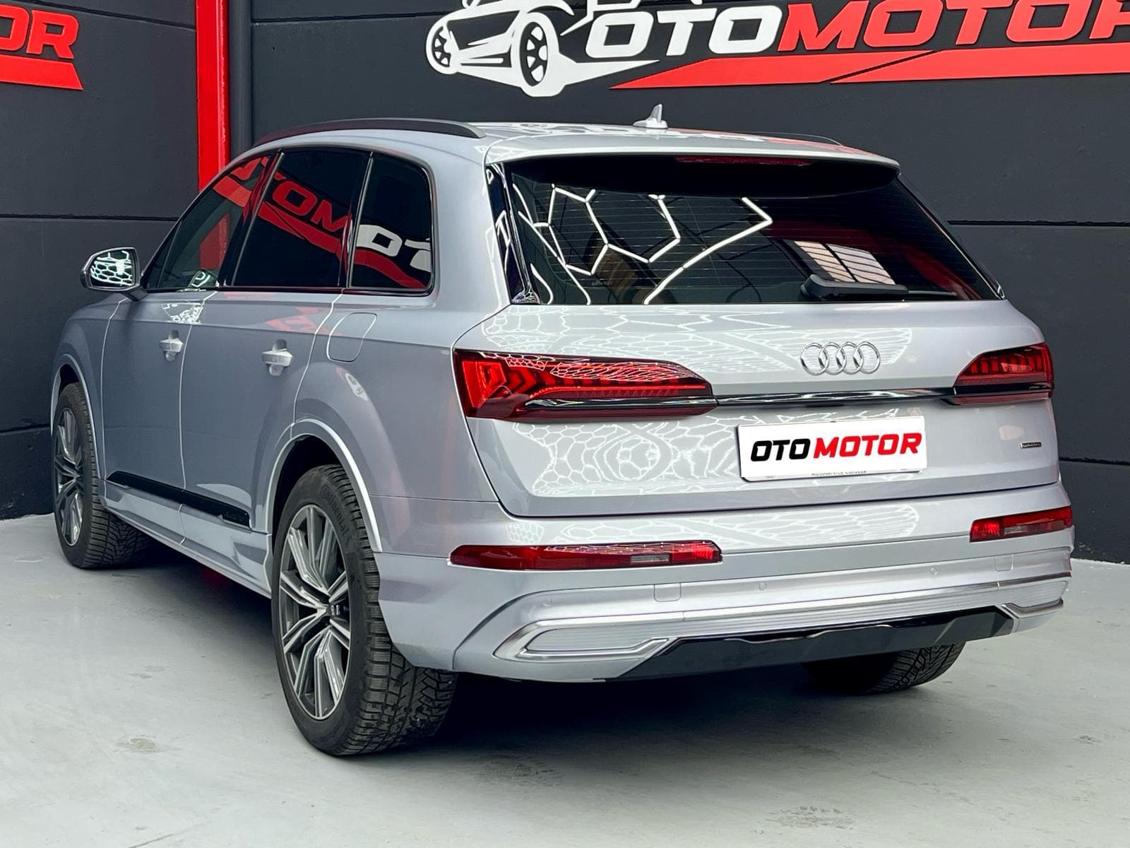 Audi Q7 55 TFSIe gris, vista trasera izquierda